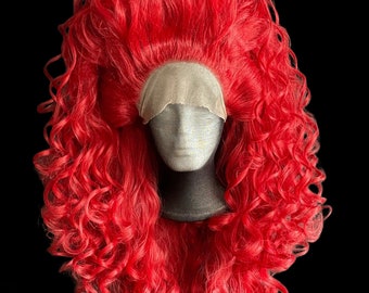 May include: A bright red curly wig on a mannequin head. The wig is styled in a large, voluminous shape with loose curls.