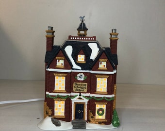 May include: A ceramic miniature boarding school with a red brick facade and a black roof. The building has multiple lit windows and the text "Boarding & Lodging School" is visible. A small wreath and a Christmas tree are on the front. The building is 15 cm tall.