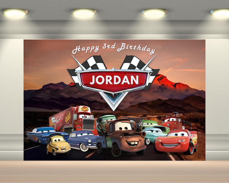 May include: A colorful birthday backdrop featuring characters from the animated movie Cars. The backdrop includes the text "Happy 3rd Birthday" and the name "Jordan" in a stylized logo, with a mountain landscape background.