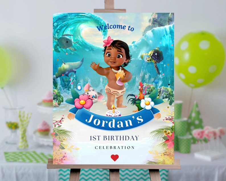 May include: Welcome to Jordan's 1st Birthday Celebration sign with a cartoon image of Moana, a tropical island scene, and a blue wave. The sign is on a wooden easel.