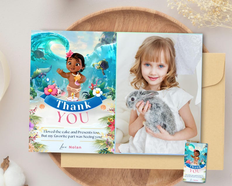 May include: A thank you card with a cartoon image of a girl dressed as Moana from the Disney movie Moana. The card has a blue and green tropical background with flowers and a wave. The text on the card reads "Thank You" and "I loved the cake and presents too, but my favorite part was seeing you! Love Nolan".