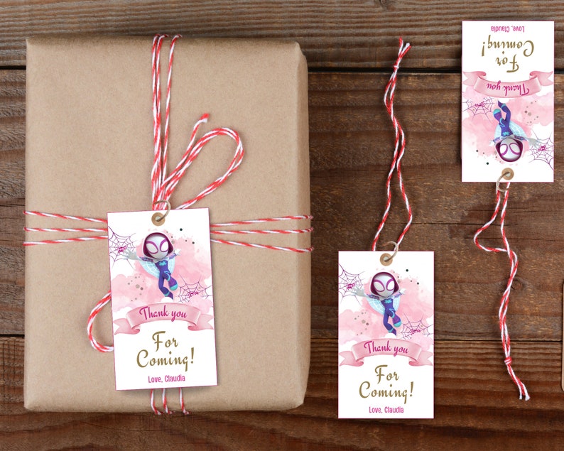 Puede incluir: Un conjunto de tres etiquetas de regalo rosas y blancas con un superh&eacute;roe de dibujos animados con un dise&ntilde;o de telara&ntilde;a. Las etiquetas tienen el texto "&iexcl;Gracias por venir! Con cari&ntilde;o, Claudia".