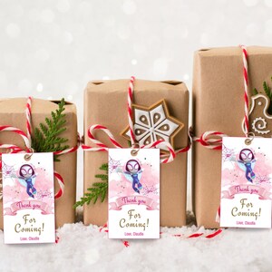 Puede incluir: Tres cajas de regalo marrones con etiquetas de regalo rosas y moradas que representan a un personaje de dibujos animados de una ara&ntilde;a-ni&ntilde;a. Las etiquetas tienen el texto "&iexcl;Gracias por venir! Con cari&ntilde;o, Claudia".