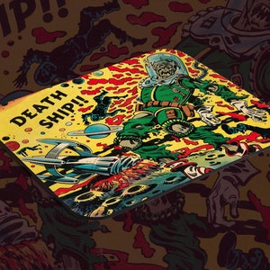 May include: A yellow and red mouse mat with a retro comic book style illustration of a spaceman in a green spacesuit holding a gun. The text "DEATH SHIP!" is printed in large letters on the mouse mat.