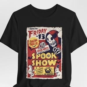May include: Black t-shirt featuring a vintage-style poster design with a skeleton in a red robe holding a sign that reads "In Person Grigor Mortis Your Best Win the Ghost!" The poster also says "Coming This Friday the 13th Cheap Chills Spook Show Curvaceous Hollywood Starlets! Live Monsters!"