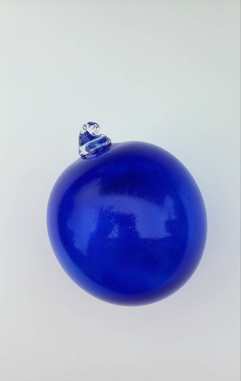 May include: A blue glass ornament with a clear glass top.