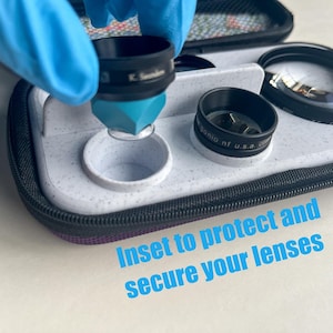 May include: A close-up of a camera lens kit with multiple lenses and a protective case. The image shows a person wearing a blue glove inserting a lens into a white holder. The text "Inset to protect and secure your lenses" is visible.