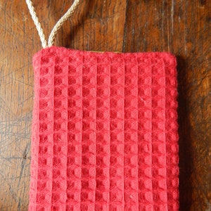 May include: Red waffle weave kitchen towel with a white loop handle.