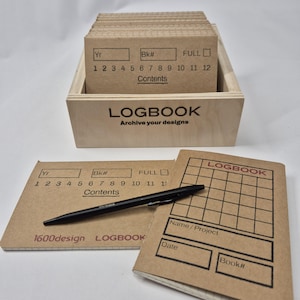 May include: A wooden box filled with kraft paper logbook cards, with a matching logbook and pen. The logbook cards have spaces for year, book number, and contents. The logbook is labeled "LOGBOOK" and "Archive your designs."