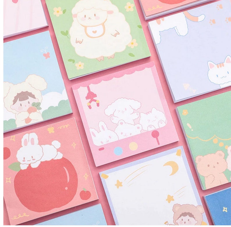 Pode incluir: Um conjunto de notas adesivas quadradas coloridas com v&aacute;rias ilustra&ccedil;&otilde;es de animais fofinhos. As notas apresentam uma ovelha, um gato, um coelho, um urso e uma menina usando um chap&eacute;u de urso. As notas s&atilde;o perfeitas para adicionar um toque de fantasia ao seu planejador, di&aacute;rio ou mesa.