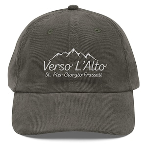May include: Olive green corduroy baseball cap with the text "Verso L'Alto" and "St. Pier Giorgio Frassati" embroidered in white. The cap features a mountain range graphic above the text.