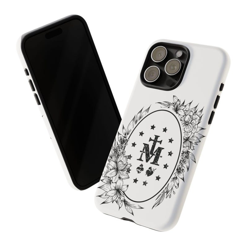 K&ouml;nnte beinhalten: Wei&szlig;es Handy-Case mit einem schwarz-wei&szlig;en Blumendesign, das ein religi&ouml;ses Symbol mit den Buchstaben "M" und "T" und einem Kreuz zeigt. Das Case hat einen Ausschnitt f&uuml;r die Kamera.