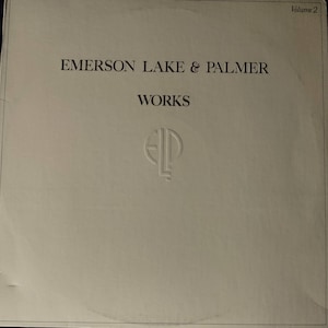 Puede incluir: Una portada de &aacute;lbum de vinilo blanco con el texto "Emerson Lake & Palmer" y "Works" en negro. La portada del &aacute;lbum tambi&eacute;n presenta el logotipo de la banda, "ELP", en un c&iacute;rculo.