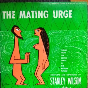 May include: A vintage record album cover with a green background featuring a cartoon illustration of a man and woman in a jungle setting. The album title is "The Mating Urge" and the text "Themes from the sound track of the motion picture composed and conducted by Stanley Wilson" is printed below the illustration.