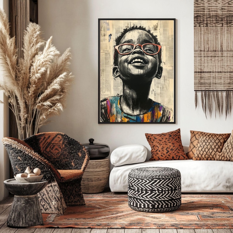 Op de afbeelding: Een ingelijste kunstdruk met een zwart-wit portret van een lachend kind met een oranje bril. Het kind kijkt omhoog, met een kleurrijk shirt. De achtergrond is een collage van krantenknipsels.