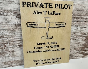 May include: A wooden plaque with the text "PRIVATE PILOT" and "Alex T LaFave" along with a small airplane illustration and the text "March 19, 2016", "Cessna 150 N10681", "Chickasha, Oklahoma KCHK", and "The sky is not the limit, It's the playground!"