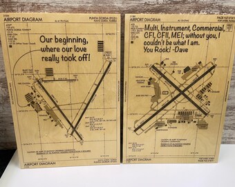 Peut inclure: Deux diagrammes d'aéroport en bois avec un message personnalisé. Le diagramme de gauche montre l'aéroport de Punta Gorda (PGD) en Floride avec le message "Our beginning, where our love really took off!" Le diagramme de droite montre le même aéroport avec le message "Multi, Instrument, Commercial, CFI, CFII, MEI; without you, I couldn't be what I am. You Rock! -Dave"
