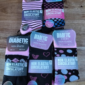 May include: Five pairs of Ezee Top diabetic socks with non-elastic, extra-wide tops. The collection includes pink and black striped, black with blue and pink dots, black with argyle patterns, black with pink hearts, and black with blue and pink dots.