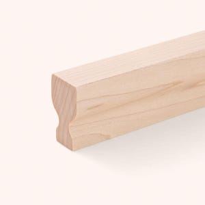 Op de afbeelding: Een lichtgekleurd, onafgewerkt houten leuningonderdeel met een gladde, natuurlijke houtnerftextuur. Het stuk heeft een opvallend profiel met een afgerond bovengedeelte en een holle inkeping langs de zijkant, met een strakke, rechte rand.