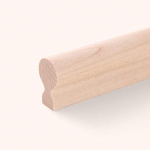 May include: A light-coloured wooden handrail with a smooth, rounded top profile and a flat base. The wood grain is visible throughout the surface, showing natural patterns in a pale beige tone. The rail features a distinct, curved shape.
