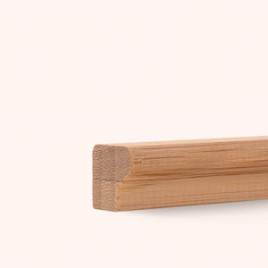 May include: A light brown bamboo molding strip with a rectangular cross-section featuring a rounded top edge. The wood grain is visible along the length of the piece, showing the natural fibrous texture of the bamboo material in a horizontal orientation.
