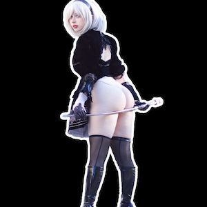 Puede incluir: Un atuendo de cosplay con un top negro, pantalones cortos blancos y botas altas negras. El personaje tiene el pelo blanco y sostiene una espada plateada. El fondo es negro.