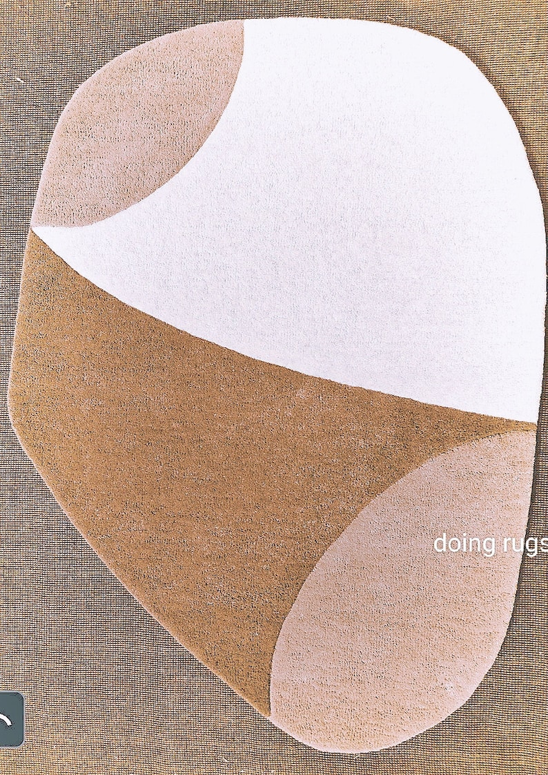 K&ouml;nnte beinhalten: Ein abstrakter Teppich mit einer einzigartigen Form, der wei&szlig;e, beige und braune Bereiche aufweist. Das Design ist geometrisch, mit geschwungenen Linien und einer weichen Textur. Geeignet f&uuml;r Wohn- oder Schlafzimmer. Ma&szlig;e in Zentimetern.