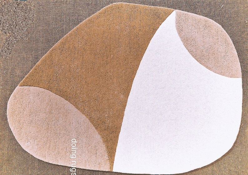 K&ouml;nnte beinhalten: Ein abstrakter Teppich mit einer einzigartigen Form und einem Farbblock-Design. Er weist Abschnitte in Braun, Beige und Wei&szlig; auf und schafft eine moderne &Auml;sthetik. Der Text "doing rugs" ist auf dem Teppich zu sehen.