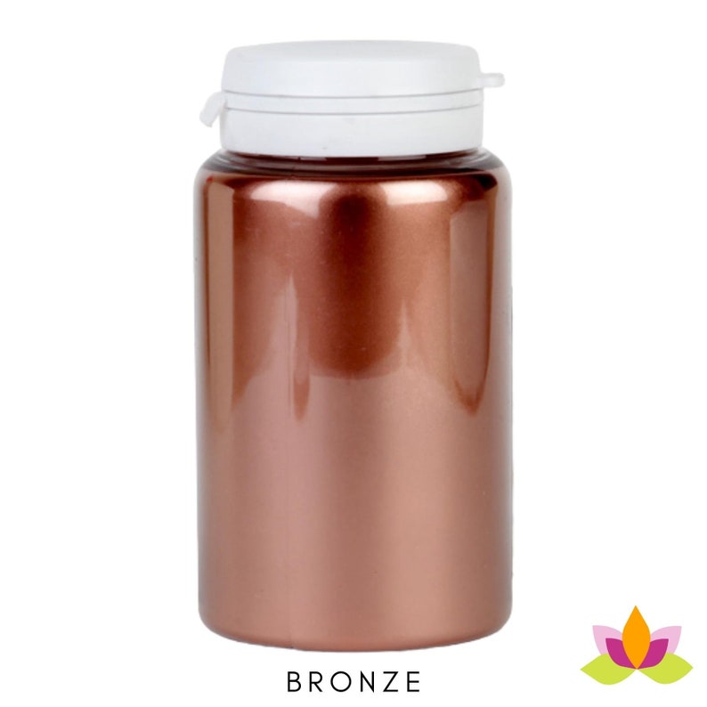 May include: A bronze colored plastic bottle with a white lid. The bottle is empty and has a shiny finish.
