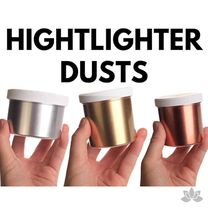 May include: Three small jars of metallic highlighter dusts. The jars are silver, gold, and copper. The jars have white lids and are held in the hands of three people.