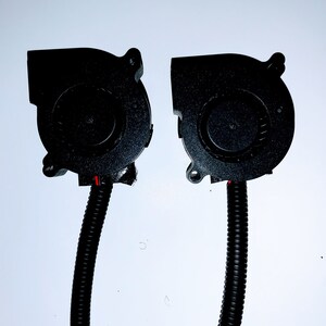 May include: Two black computer cooling fans with black wires attached. The fans have a black plastic housing and a black impeller.