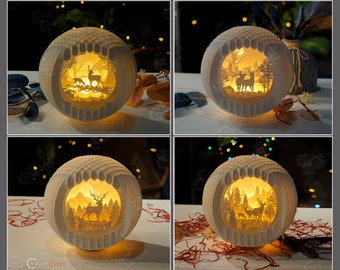 May include: Four white paper lamps with intricate cut-out designs of a forest scene with deer. The lamps are illuminated from within, casting a warm glow.