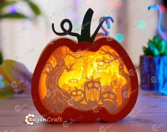 May include: A wooden pumpkin-shaped lamp with a Halloween-themed scene inside. The scene features a spooky forest with trees, a house, and a graveyard. The lamp is lit up from the inside, creating a warm glow.