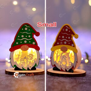 Pode incluir: Duas pequenas decora&ccedil;&otilde;es de gnomos de Natal iluminadas. Um gnomo tem um chap&eacute;u verde com bolinhas brancas, o outro um chap&eacute;u vermelho com bolinhas brancas. Ambos t&ecirc;m uma base de madeira e um design recortado mostrando uma cena de inverno. A palavra "Small" est&aacute; acima dos gnomos.