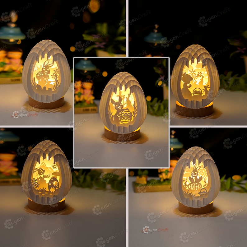 May include: Five white paper Easter egg shaped night lights with different bunny and egg designs. Each light is on a wooden base.