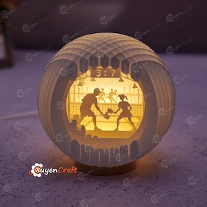 May include: A spherical, illuminated paper art lamp featuring a pickleball scene. The lamp has a layered design with a detailed court and players. The time "3:7" is displayed. The lamp is on a wooden base and emits a warm glow.