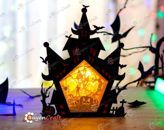 May include: A black papercraft Halloween haunted house with a glowing orange light inside. The house has a spider web, a pumpkin, and a spooky figure inside.
