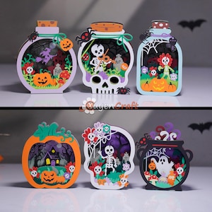 Op de afbeelding: Zes gelaagde papieren decoraties met Halloween-thema's, waaronder pompoenen, skeletten, geesten, spookhuizen en grafstenen. Elk stuk is ingewikkeld uitgesneden met levendige kleuren zoals oranje, paars, groen en zwart, met gedetailleerde scènes van griezelige figuren.