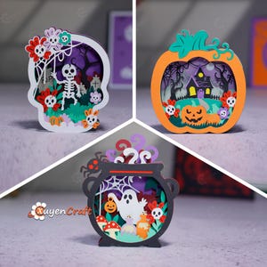 May include: Three layered wooden Halloween decorations featuring a white skull frame with a skeleton, an orange pumpkin frame with a haunted house, and a black cauldron frame with a ghost, spider, and mushrooms, all with colorful floral accents.