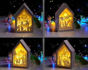 May include: Four white wooden Christmas light-up houses with different scenes inside. The scenes include a nativity scene, a winter forest with a deer, a winter forest with a snowman, and a winter forest with a cabin. The houses are lit from the inside with warm white LED lights.