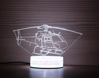 May include: A white LED night light shaped like a helicopter. The helicopter is outlined in white and is on a white base with a textured surface.