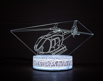 May include: A white 3D printed night light shaped like a helicopter. The helicopter is on a white base with a textured surface.