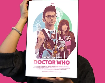 May include: A poster that is 11x17 inches featuring David Tennant from Doctor Who. The poster has a colorful design with the text "DAVID TENNANT IS DOCTOR WHO" and the year 2023. The poster is held up by a person.