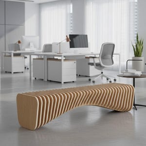Könnte beinhalten: Eine moderne, geschwungene Holzbank mit hellbraunem Finish. Die Bank besteht aus geschichteten, gebogenen Holzlatten. Der Hintergrund zeigt ein helles Büro mit Schreibtischen, Stühlen und Pflanzen.