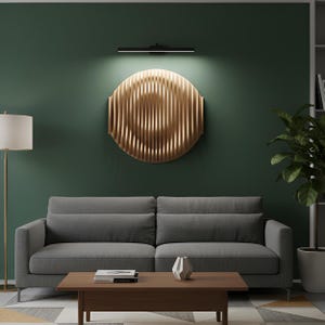 Puede incluir: Un sal&oacute;n moderno con un sof&aacute; gris, una mesa de centro de madera y una gran obra de arte mural circular dorada. Una l&aacute;mpara de pie y una planta en maceta completan la decoraci&oacute;n. La pared est&aacute; pintada de verde oscuro.