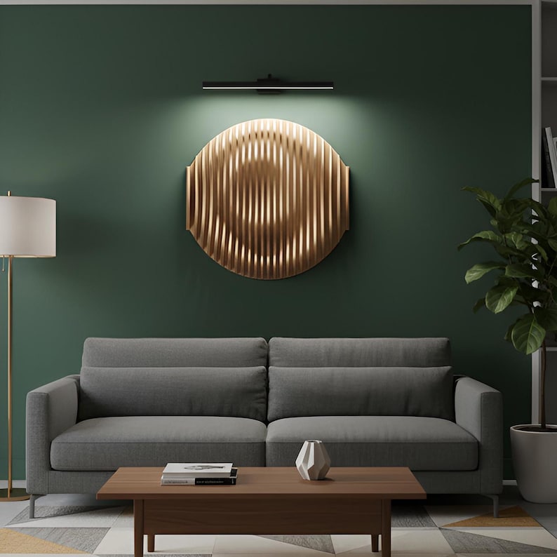 Puede incluir: Un sal&oacute;n moderno con un sof&aacute; gris, una mesa de centro de madera y una gran obra de arte mural circular dorada. Una l&aacute;mpara de pie y una planta en maceta completan la decoraci&oacute;n. La pared est&aacute; pintada de verde oscuro.
