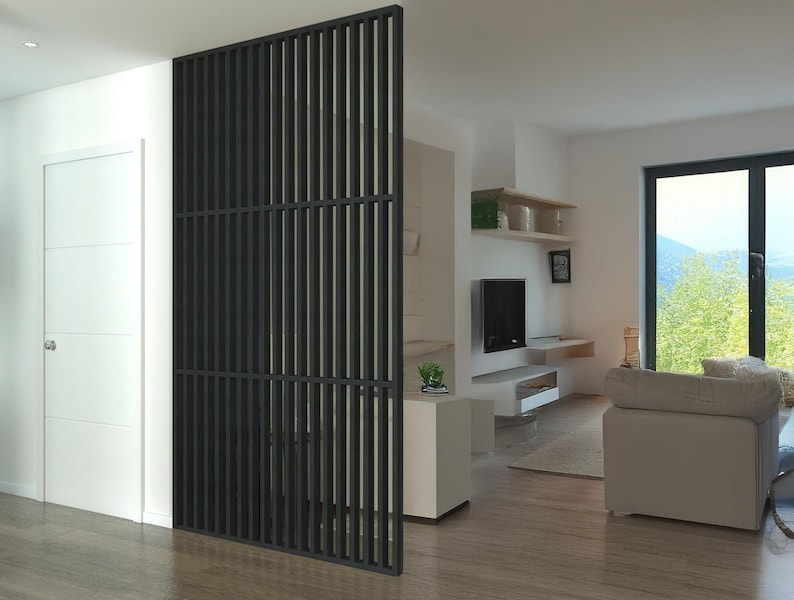 Modern living space with a black slatted partition, white walls, a cozy seating area, and large windows overlooking a scenic outdoor view.