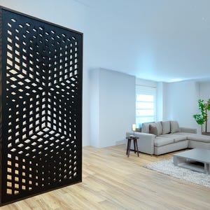 May include: A black room divider with a geometric pattern. The divider is made of wood and has a modern design. The divider is in front of a living room with a couch and a coffee table.