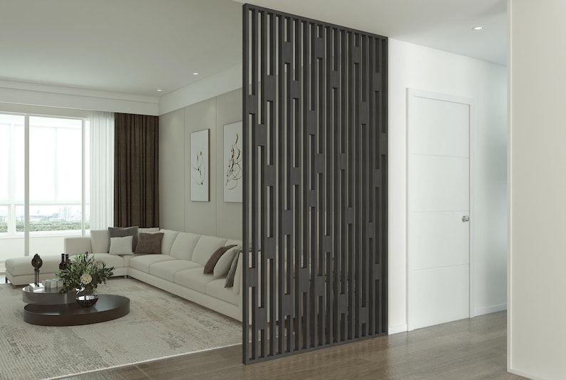 Modern living room with a black geometric slatted partition, neutral-toned sectional sofa, decorative wall art, and large windows with natural light.