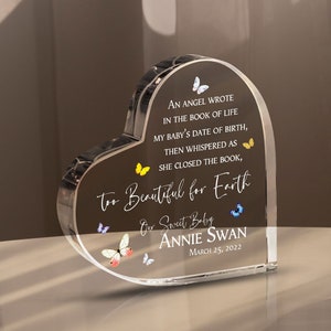 May include: A clear heart-shaped crystal paperweight with a butterfly design and the text "An angel wrote in the book of life my baby's date of birth, then whispered as she closed the book, Too beautiful for Earth. Our sweet baby Annie Swan March 25, 2022."